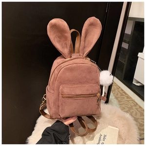 Détail du mini sac à dos en daim rose poudré avec oreilles de lapin et pompon
