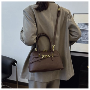 Close-up of a vintage shell-shaped shoulder bag in dark brown with gold hardware detail