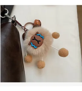 Close-up of a plush bear bag charm with furry details hanging on a brown leather handbag