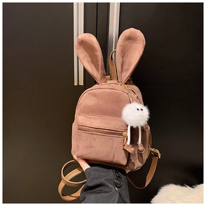 Détail d'un mini sac à dos en daim marron avec des oreilles de lapin ludiques et un pompon blanc
