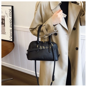 Detailed view of a black vintage shell bag with gold hardware and buckle accents