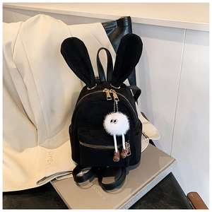 Détail d'un sac à dos noir à oreilles de lapin avec pendentif monstre en peluche