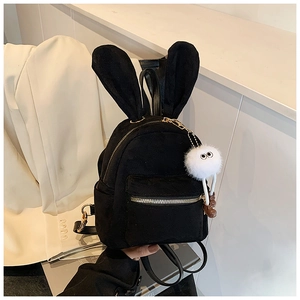 Détail d'un mini sac à dos noir avec oreilles de lapin et pompon en peluche blanche