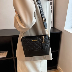 Close-up of quilted black crossbody bag with gold FRAWIROR logo and patterned strap
