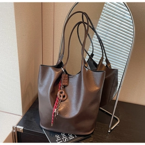 Détail du sac cabas en cuir marron foncé avec charme chocolat et poignée en corde tressée