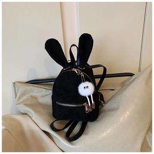 Détail d'un sac à dos en daim noir avec oreilles de lapin et pompon blanc décoratif