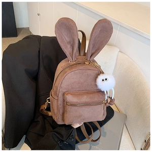 Détail d'un mini sac à dos marron en faux daim avec oreilles de lapin et pompon blanc