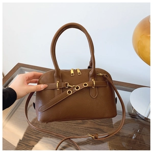 Detail of a brown vintage shell bag with gold metallic buckle and adjustable shoulder strap