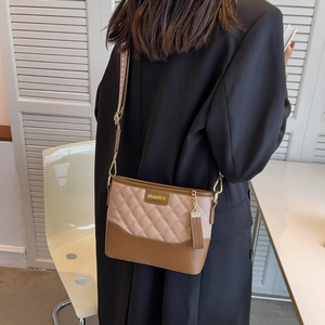 Quilted crossbody bag with dual-tone brown panels and adjustable geometric strap detail