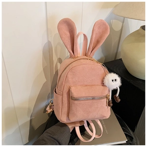 Vue détaillée du mini sac à dos rose en daim avec oreilles de lapin et pendentif peluche