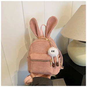 Vue détaillée d'un mini sac à dos en daim rose avec oreilles de lapin et peluche