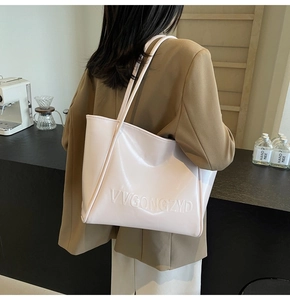 Dettaglio della borsa tote in pelle bianca lucida con logo VVGONGZYD a rilievo sulla tracolla