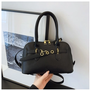 Close-up of black shell handbag with gold ring buckles and smooth double zipper details