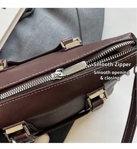 Détail du sac en cuir marron avec fermeture éclair argentée et coutures contrastées