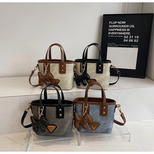 Détails de quatre sacs seaux bicolores avec logo triangulaire et breloque