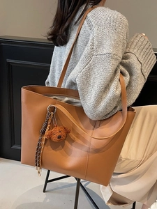 Sac fourre-tout vintage marron en similicuir avec breloque ours, porté par un mannequin