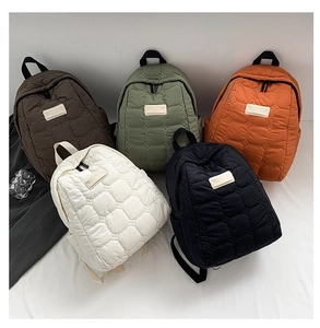 Quilted nylon backpack display showing five colors with geometric stitching and top handles