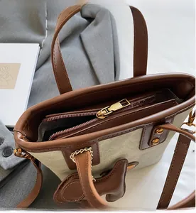 Détail de la fermeture éclair dorée lisse et de la doublure rayée du sac cabas en toile
