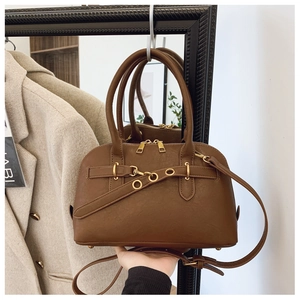 Close-up of caramel brown tote bag with gold hardware and grainy leather texture