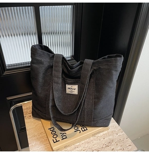 Close-up of denim tote bag showing fabric texture, white Fbbag label, and contrast stitching