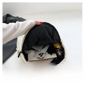 Internal storage display of the quilted backpack holding a phone, notebook, and umbrella
