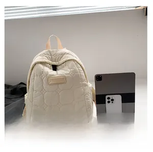 Quilted backpack in cream white showing size comparison with a tablet and phone