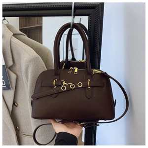 Detail of vintage dark brown shell bag with golden metal rings and double zippers