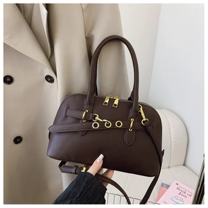 Detail of dark brown vintage Boston handbag with gold hardware and stylish leather straps