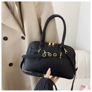 Detail of black vintage satchel with gold ring buckles and adjustable strap