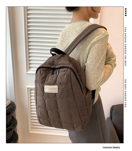 Dunkelbrauner gesteppter wasserdichter Rucksack von einem Modell in Innenräumen getragen