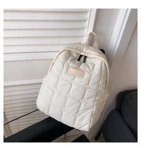 Nahaufnahme der beige gesteppten wasserdichten Nylon-Rucksackdetails auf einem Stuhl