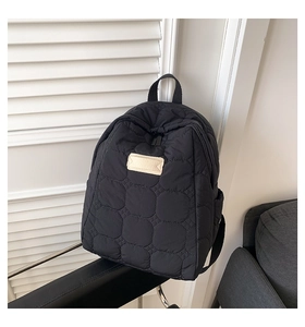 Detailaufnahme des schwarzen gesteppten Rucksacks mit weicher Textur und runden Nähten