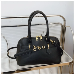 Detail view of black vintage shell bag with gold hardware and dual zipper closure