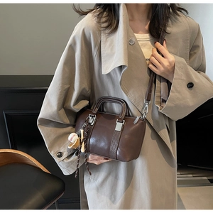 Vue détaillée du sac Boston marron foncé avec charme baseball et boucles métalliques