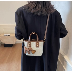 Sac seau en toile avec bordure en cuir marron et breloque chiot porté en bandoulière