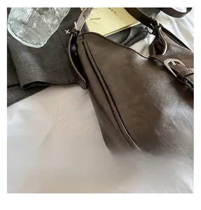 Gros plan détaillé du sac seau en cuir PU marron foncé avec boucle métallique réglable
