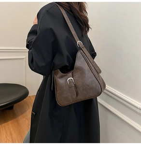 Vue détaillée d'un sac à bandoulière marron foncé vintage avec boucle argentée et texture cirée