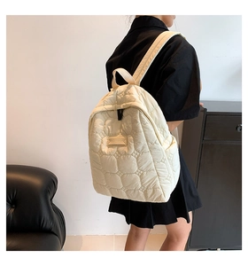 Detail der gesteppten Blumenmuster am cremefarbenen Rucksack mit Tragegurten