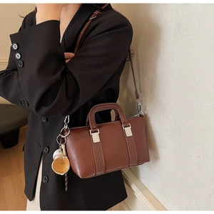 Sac Boston en cuir marron avec coutures blanches et breloque gant de baseball créative