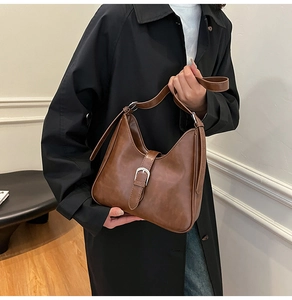 Gros plan détaillé du sac bandoulière en cuir PU marron avec boucle vintage et sangle