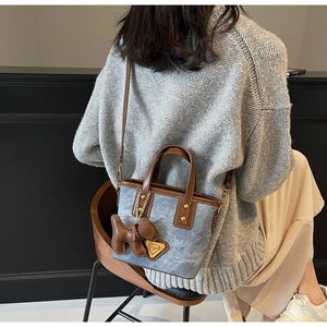 Vue détaillée d'un mini sac en denim avec bordures en cuir et charm chiot mignon