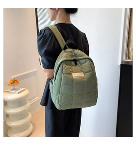 Detailansicht eines hellgrünen gesteppten Rucksacks mit Rautenmuster an einem Model