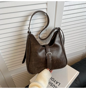 Détail du sac seau marron vintage avec boucle argentée et bandoulière réglable