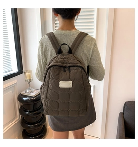 Nahaufnahme des braunen Stepprucksacks mit Hexagon-Mustern und weißem Logo-Patch