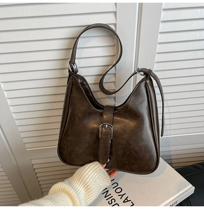 Gros plan du sac seau vintage en cuir marron avec boucle argentée et texture en PU