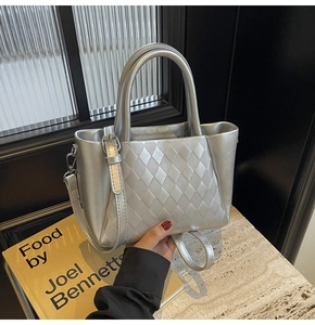 Detail view of silver crossbody bag with rhombic pattern and metallic faux leather texture