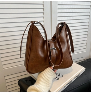 Détail d'un sac seau vintage marron avec boucle en métal argenté et ouverture en forme de V