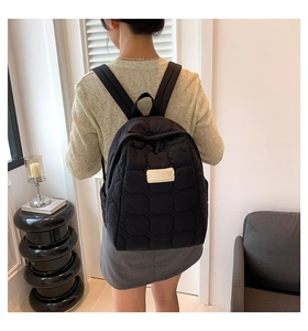 Detailansicht eines schwarzen gesteppten Nylon-Rucksacks mit gepolsterten Schultergurten