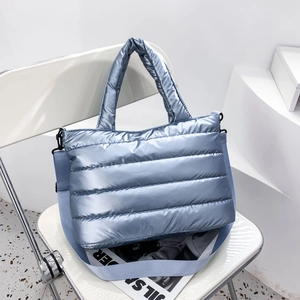 Detailaufnahme der metallic-hellblauen Stepptasche mit Tragegriff und Schultergurt