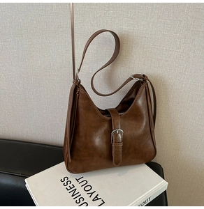 Détail du sac hobo en cuir marron avec texture vintage et boucle en métal argenté